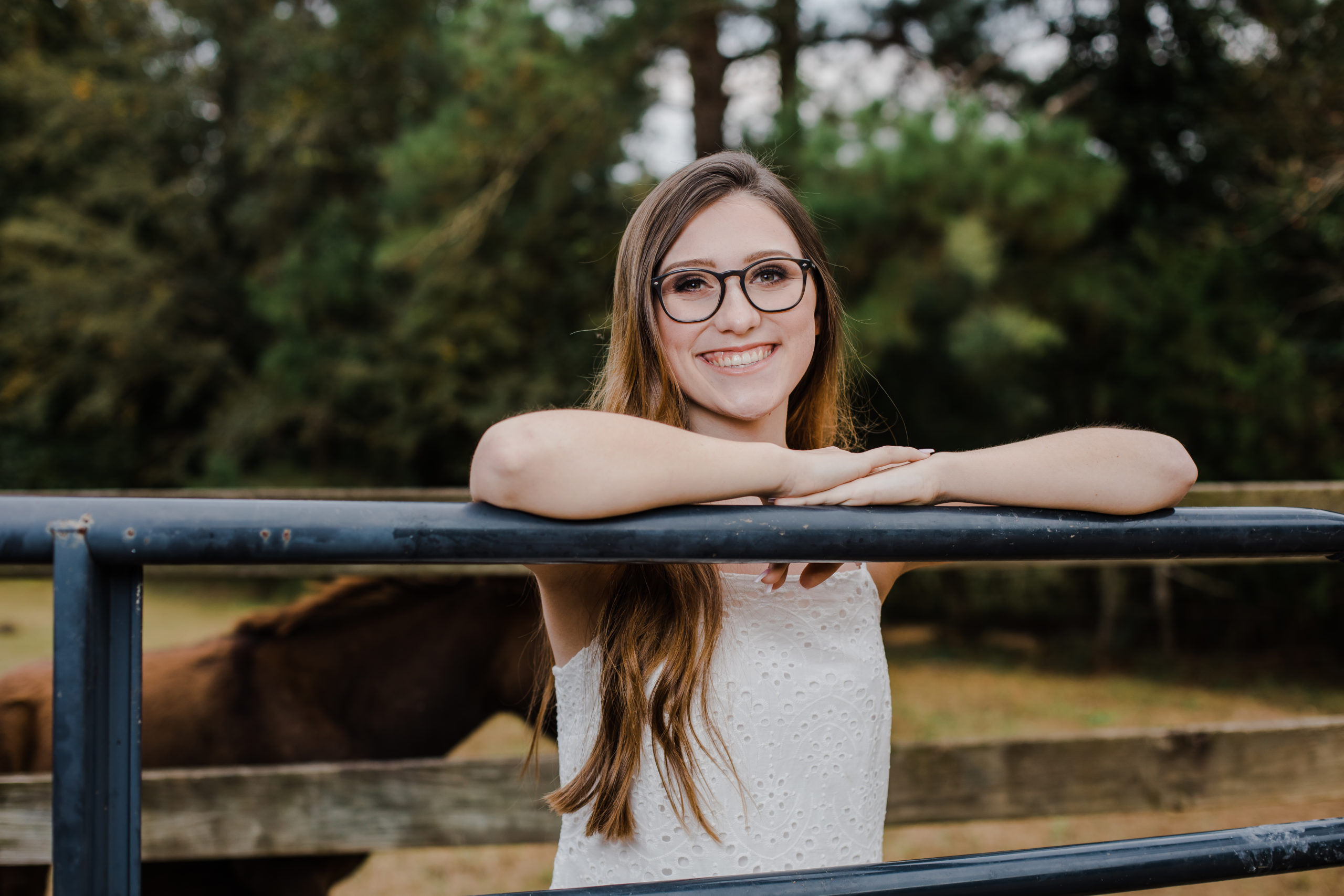 senior session with girl leaning on a fence at a barn in the country with Augusta photographer