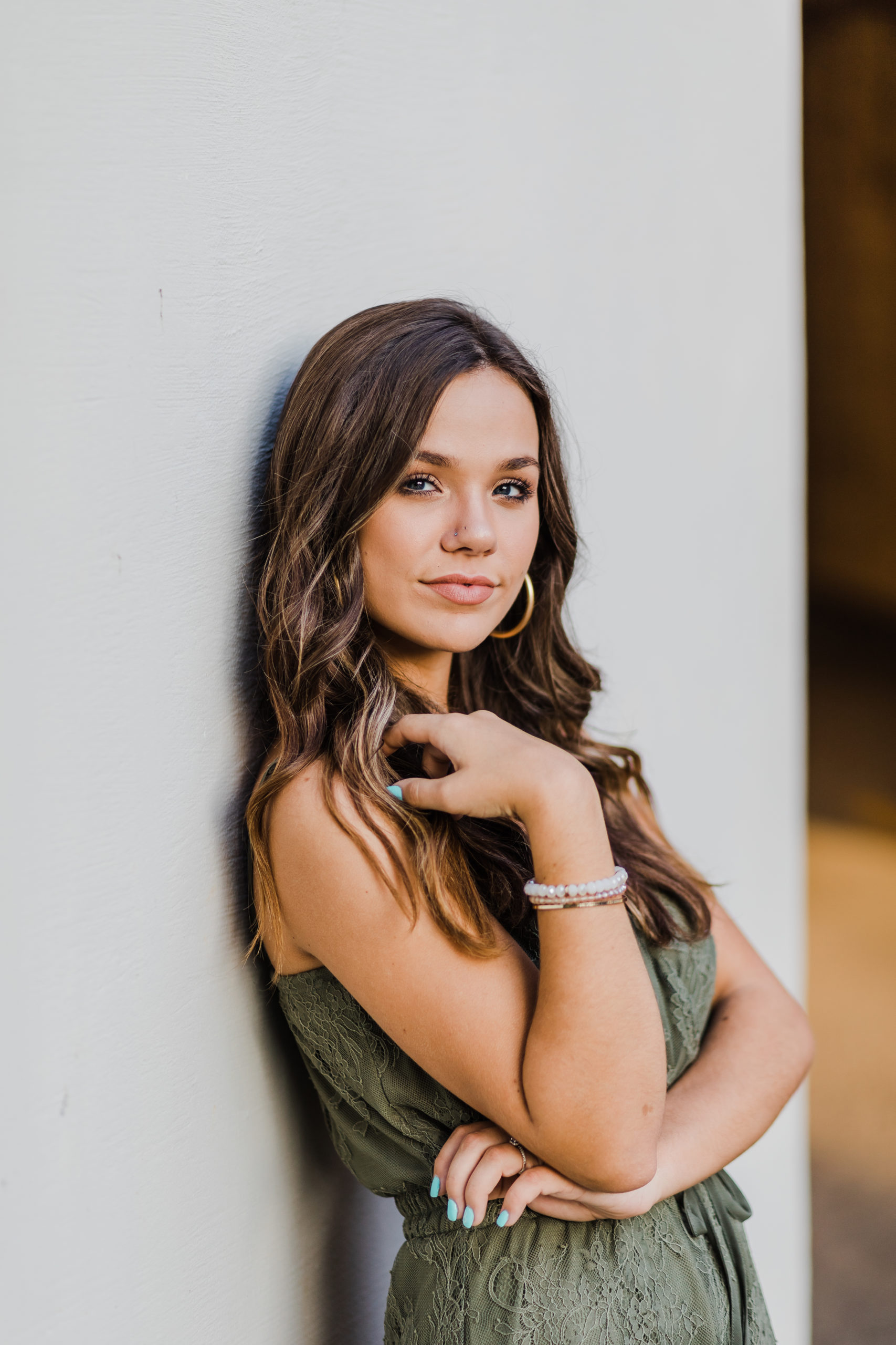Georgia senior photogrpher captures girl leaning against a wall and holding her hair