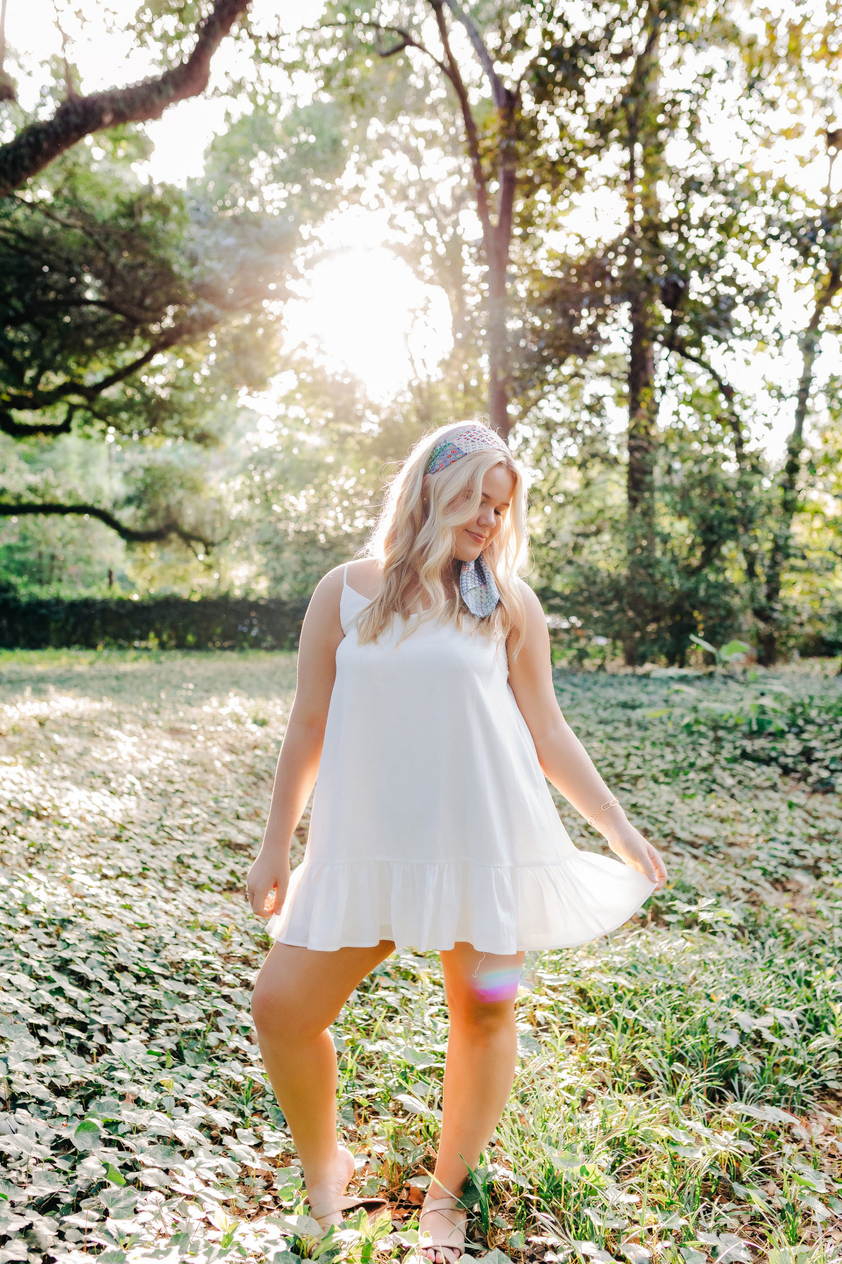senior pictures with girl dancing in a white dress in a garden captured by aiken photographer
