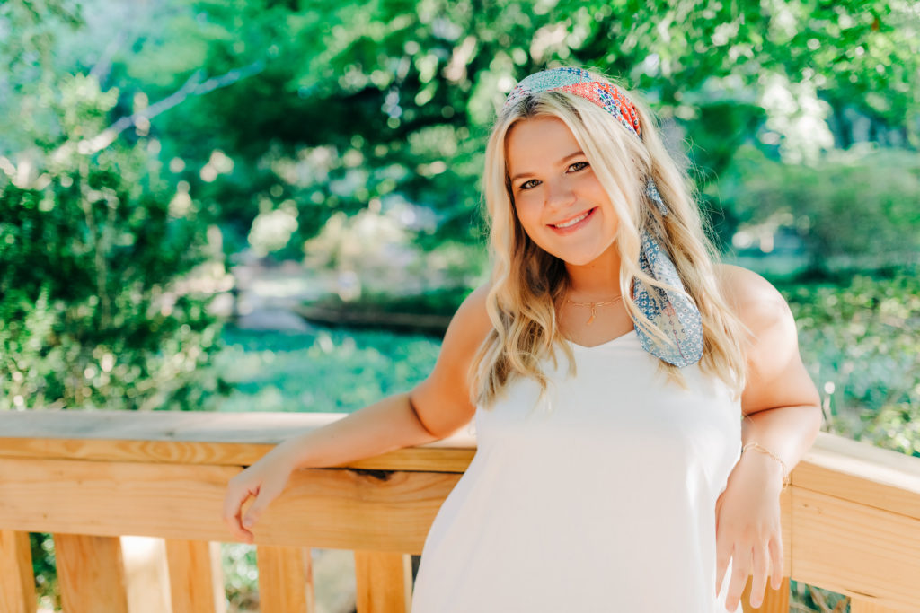 young woman in a white dress for her summer senior portraits