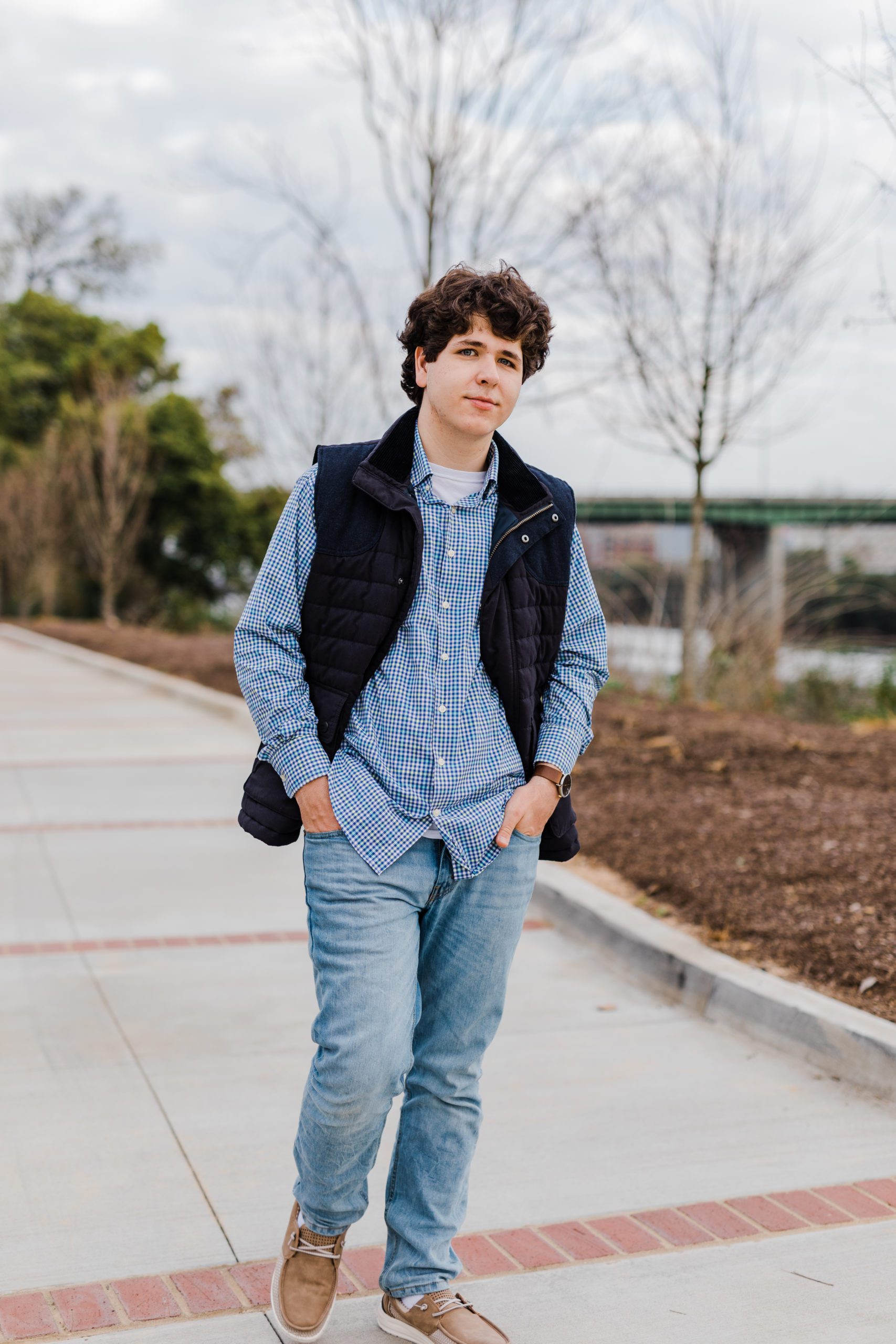 senior picture with boy holding his hands in his pockets and walking down a path taken by Augusta photographers