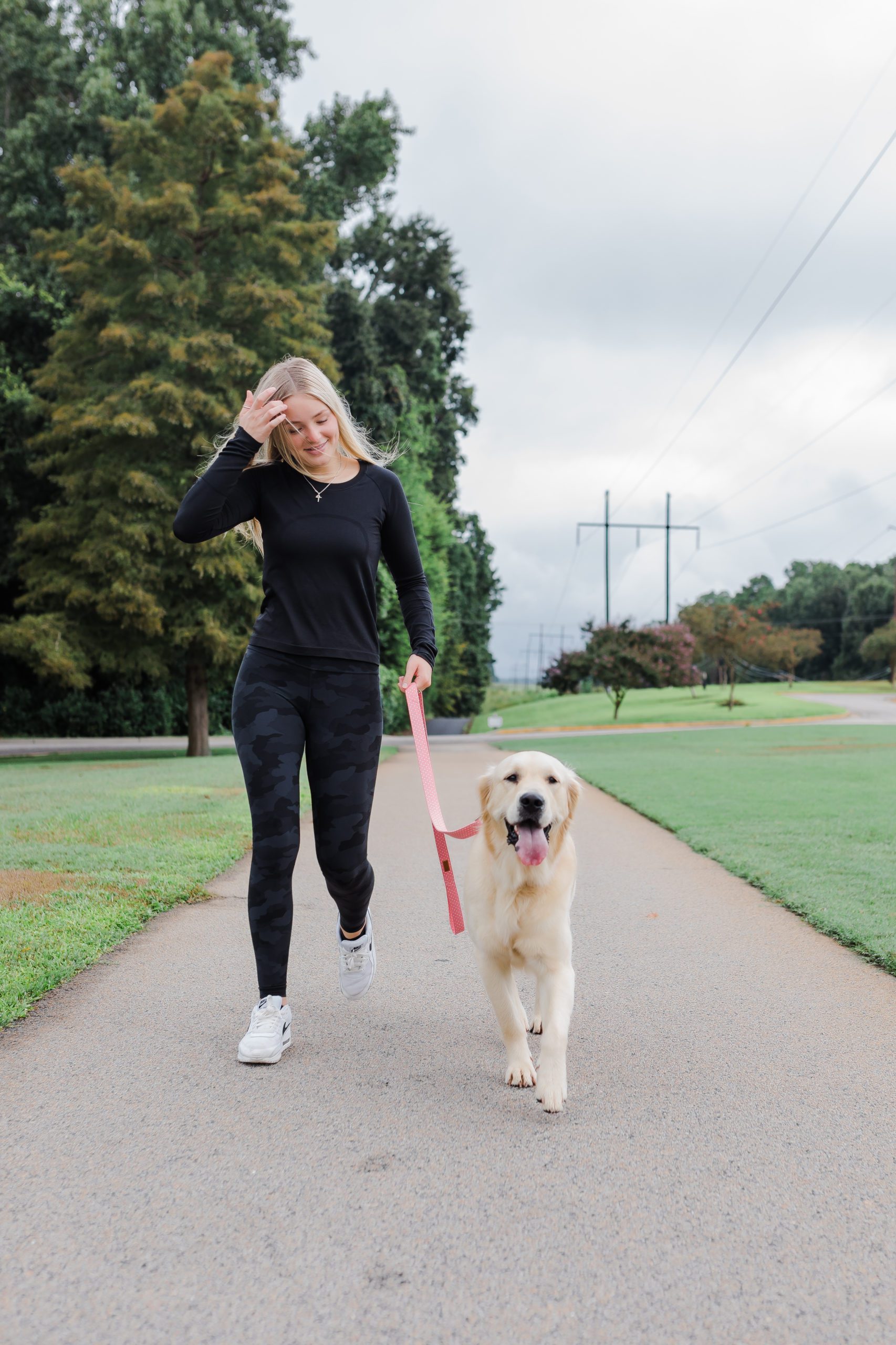 women walking a dog in a park on a path for branding photography for Puddle Jumper Pups
