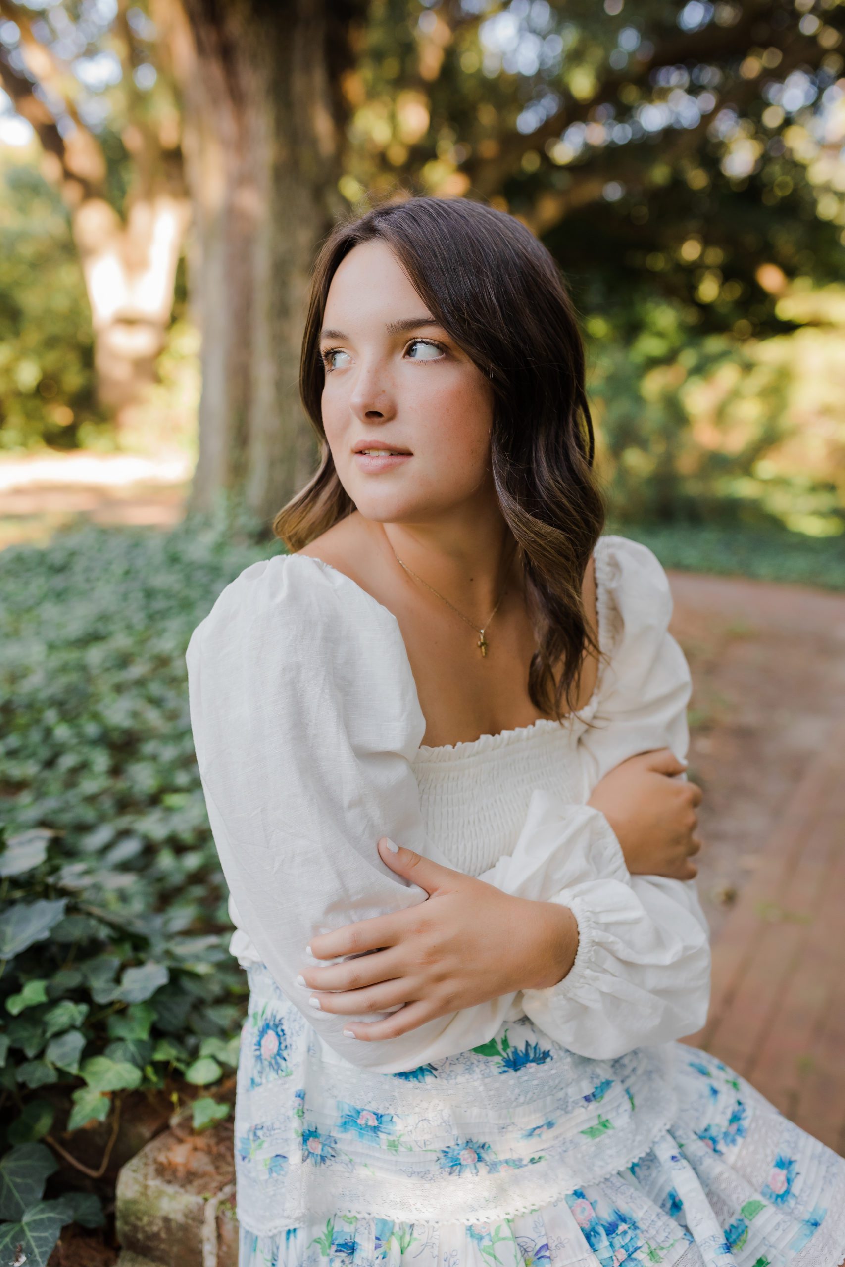 Augusta photographer captures senior pictures with girl in a white top in a garden for her outdoor senior pictures 